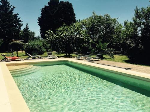 - une grande piscine avec des chaises longues dans la cour dans l'établissement Le Cigaloun, à Orange