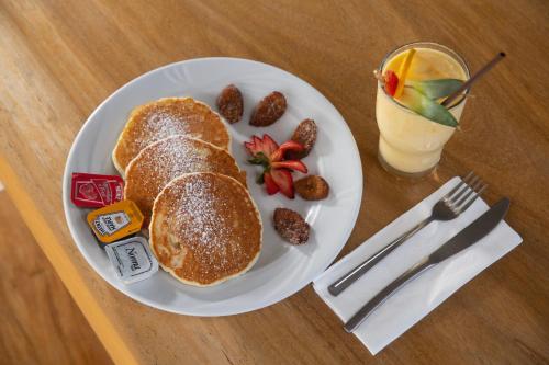 a plate of food with pancakes and fruit and a drink at Hotel 52 Playa del Carmen in Playa del Carmen