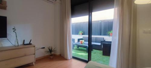 Zimmer mit Glasschiebetür zum Wohnzimmer in der Unterkunft Apartamentos Motilla del Azuer in Daimiel