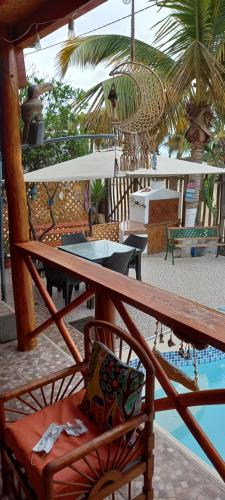 einen Balkon mit einem Tisch, Stühlen und einem Pool in der Unterkunft Salv lodge casa frente al mar in Zorritos