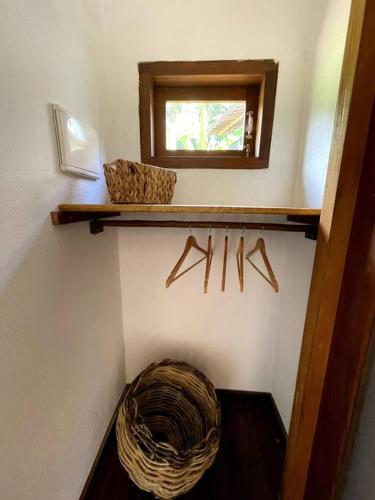 a bathroom with a mirror and a basket on a shelf at Casa do Jardim in Serra Grande