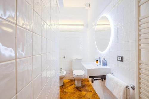 Baño blanco con lavabo y aseo en Condotta 16 Apartments, en Florencia