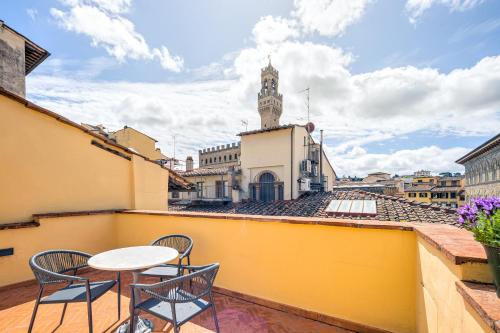 a balcony with a table and chairs and a clock tower at Condotta 16 Apartments in Florence