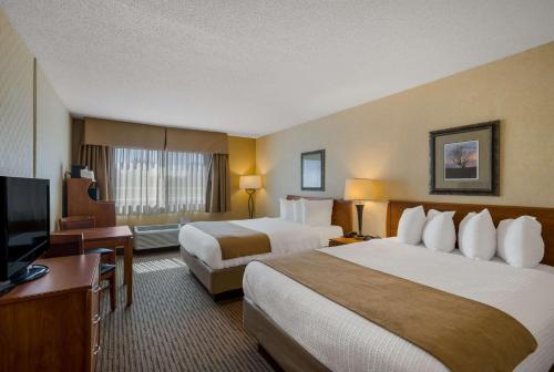 a hotel room with two beds and a flat screen tv at Best Western Vermillion Inn in Vermillion