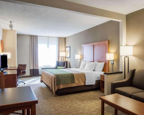 a hotel room with a bed and a desk and a couch at Comfort Inn & Suites West Chester - North Cincinnati in West Chester