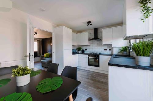 eine Küche und ein Wohnzimmer mit einem Tisch und Stühlen in der Unterkunft ComfySleep ApartHOUSE in Glasgow
