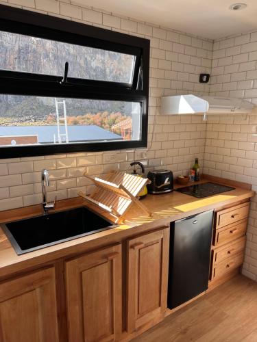 een keuken met een wastafel en een raam bij Desierto Suites in El Chalten
