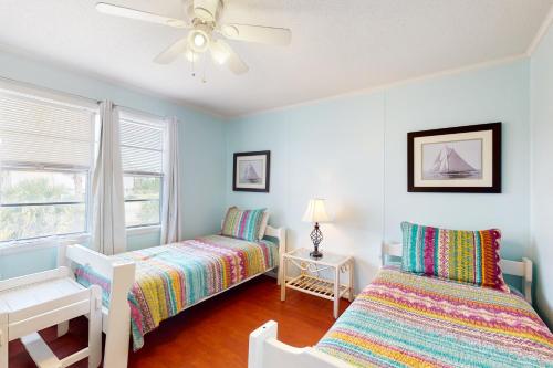a bedroom with two beds and a ceiling fan at Abaco House in Gulf Shores