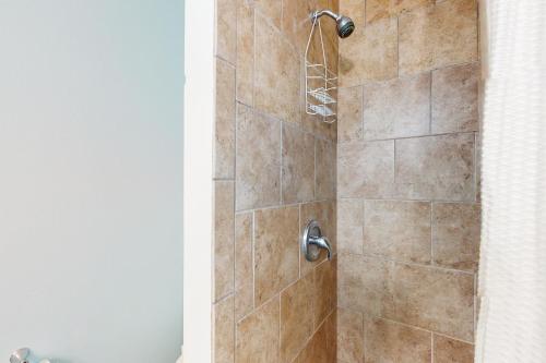a shower with a brown tiled shower at Abaco House in Gulf Shores