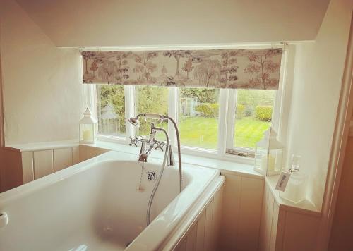 a bath tub in a bathroom with a window at Burnley country house in Hutton le Hole