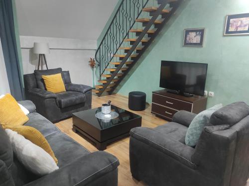 uma sala de estar com sofás e uma televisão de ecrã plano em Apartments Vila Knez em Zlatibor