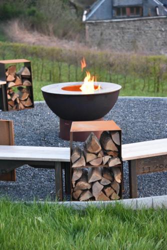 a fire pit sitting next to a pile of fire wood at Rochehaut, Les Semoiselles, Villa Isabelle in Bouillon