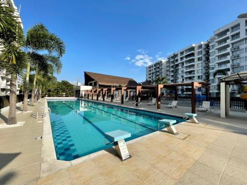 a large swimming pool with chairs and a building at Moderno apartamento amoblado via Ricaurte-Girardot in Ricaurte