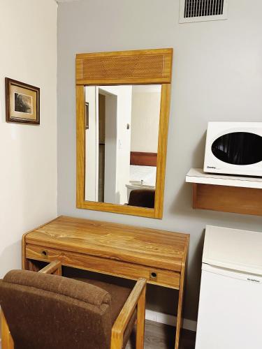 a mirror on a table with a chair and a microwave at Uptown Motel in Estevan