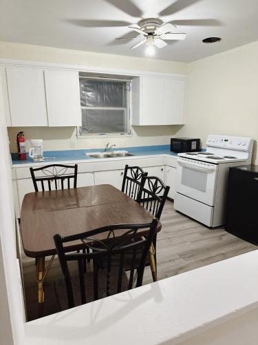 a kitchen with a table and chairs and a stove at Uptown Motel in Estevan