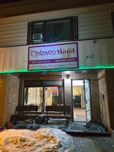a sign for a restaurant with two benches in front at Uptown Motel in Estevan