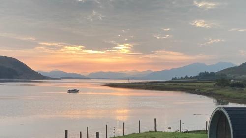 a boat on a river with mountains in the background at Sunset POD in Dunan