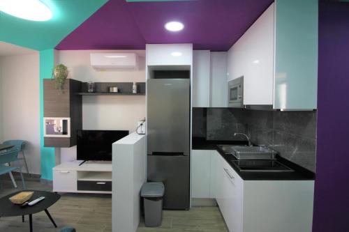 a kitchen with white cabinets and purple ceilings at CASATURIS NEWON APARTAMENTOS en EL CAMPELLO in El Campello