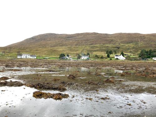 a muddy field with houses and houses in the background at Sunset POD in Dunan