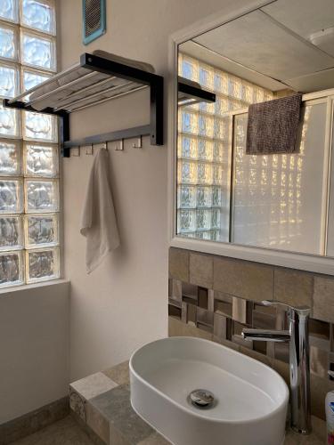 a bathroom with a large white sink and a mirror at Posada Catalina in Zacatlán