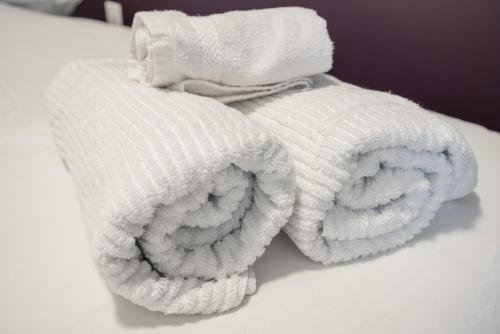 two white towels sitting on top of a bed at Brand new beautiful 3 beds 2 bathroom condo in Niagara Falls
