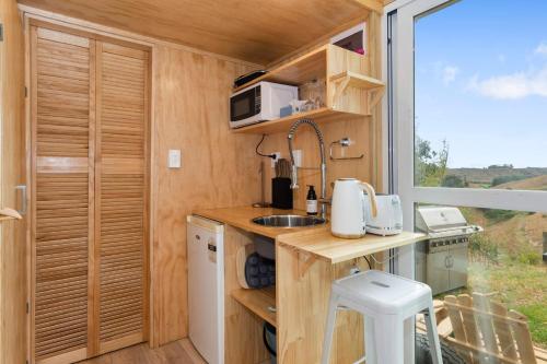uma cozinha numa pequena casa com uma janela em Rural Couples Retreat/Tiny House em Pukehina