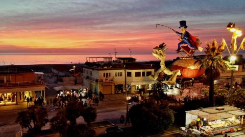 a group of people walking around a town at sunset at Hotel San Francisco in Viareggio