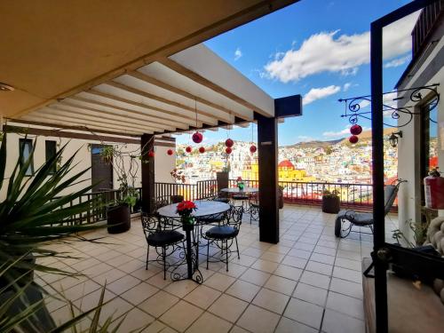 a patio with tables and chairs and a view of a city at Hotel Chocolate Tradicional in Guanajuato