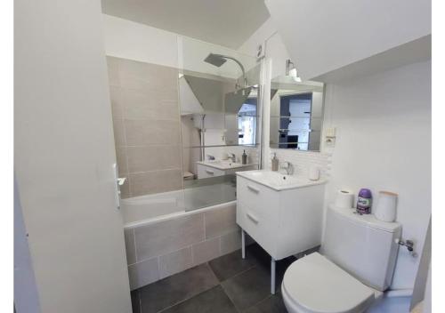 Superbe appartement avec jardin proche Versailles في سا سير لوكول: حمام مع مرحاض ومغسلة وحوض استحمام