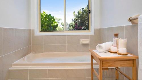 uma casa de banho com uma banheira e uma janela em Terra Bella em Robertson
