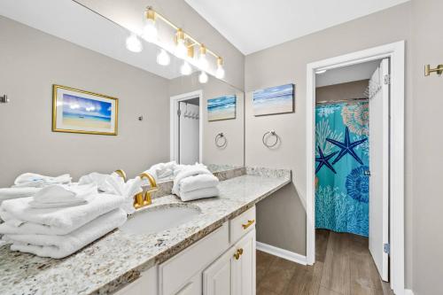 een witte badkamer met een wastafel en een spiegel bij Phoenix VII 71113 by ALBVR - Beautiful Beachfront Condo with Amazing Views & Amenities! in Orange Beach