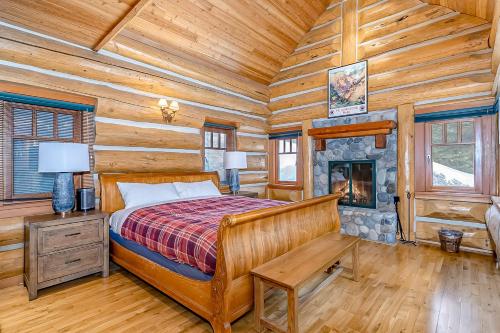 a bedroom with a bed and a fireplace in a log cabin at Seattle Mountain Home in Snoqualmie Pass