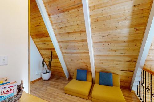 two yellow chairs in a room with wooden walls at Peaceful Pine Getaway in Dorrington