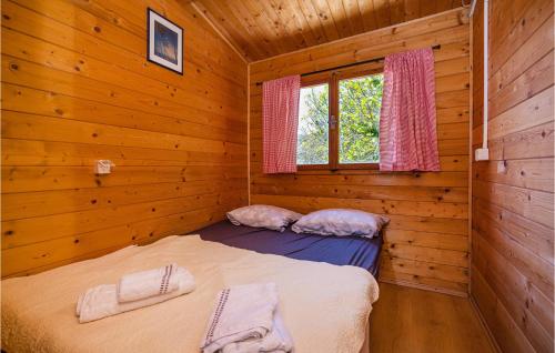1 dormitorio con 2 camas en una cabaña de madera en Amazing Home In Mali Iz With Kitchen en Mali Iž