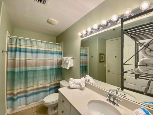 La salle de bains est pourvue d'un lavabo, de toilettes et d'un miroir. dans l'établissement Island Royale P403 by ALBVR - Beautiful Beachfront Penthouse Level Condo!, à Gulf Shores
