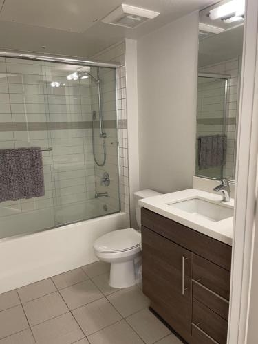 W łazience znajduje się toaleta, umywalka i prysznic. w obiekcie Las Palmas - Modern, Stylish, Spacious, Secure & Tranquil Condo with 2 Master Suite Bedrooms - WLK to SM Pier w Los Angeles