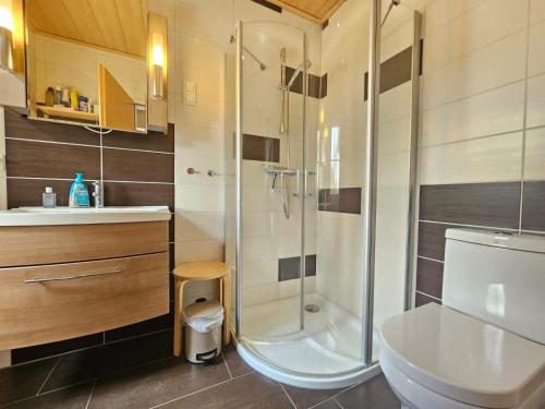 a bathroom with a shower and a toilet and a sink at Ferienhaus Merlin in Norden