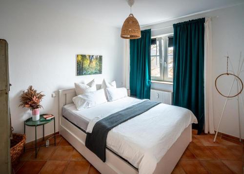 a bedroom with a large bed with green curtains at 3-Raum-Appartement Hygge in Sassnitz