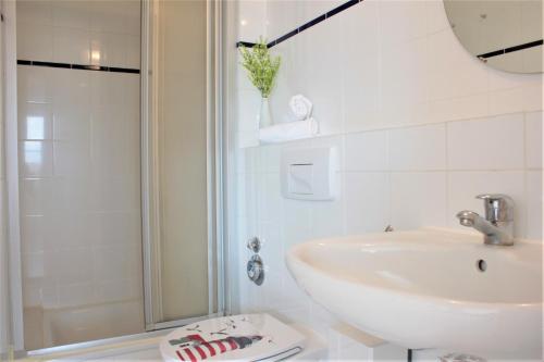 y baño blanco con lavabo y ducha. en BreitlingBlicke, en Gollwitz