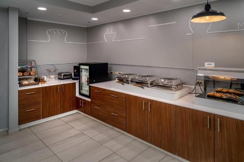 a kitchen with wooden cabinets and a counter with food at Holiday Inn Express - Charleston/Kanawha City by IHG in Charleston