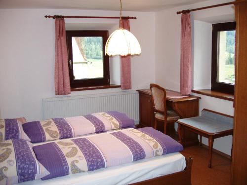 1 dormitorio con 1 cama, escritorio y 2 ventanas en Haus Sonnleite, en Trins