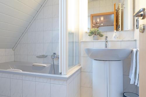 La salle de bains est pourvue d'un lavabo et d'une baignoire. dans l'établissement Haus Schwanensee Seeblick Bischofsee, à Bosau