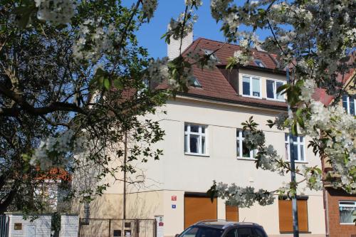 a white house with a red roof at Pension Hanspaulka in Prague