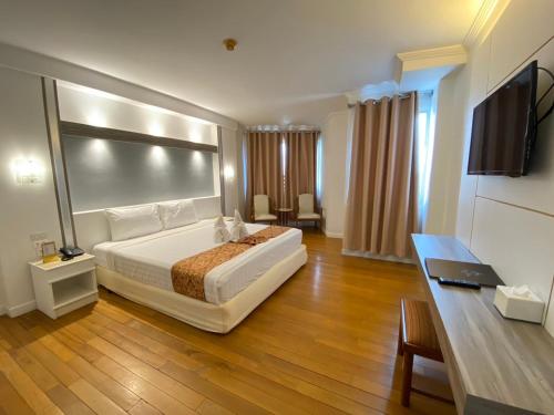 a hotel room with a bed and a flat screen tv at Thong Tarin Hotel in Surin