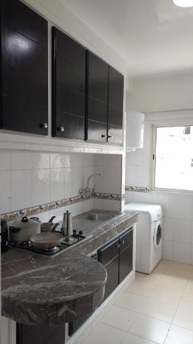 a kitchen with a sink and a stove top oven at Apartment in the city center, 2 minutes walk from the tram in Rabat