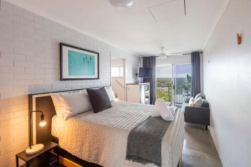 Un dormitorio con una cama grande y una ventana grande. en Yamba Views Angourie Room 11, en Yamba