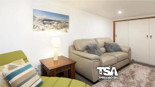 a living room with a couch and a table at Ski Fall at Lake Crackenback in Crackenback