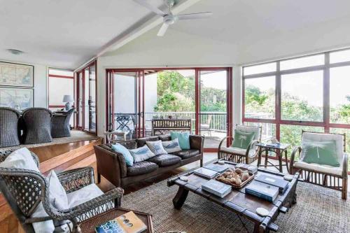 a living room with a couch and a table at Castaways Beach House Noosa in Marcus Beach