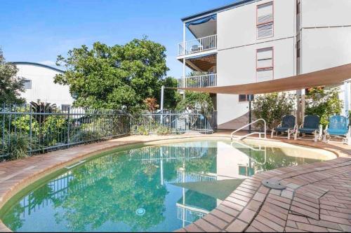 a swimming pool in front of a building at Castaways Beach House Noosa in Marcus Beach