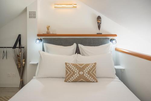 a bedroom with a white bed with white pillows at Studio Mare Gaillard in Le Gosier